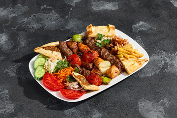 Grill assorted platter with kebab, pide, and vegetables, bright lighting, overhead composition