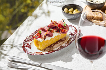 Baked polenta with roast beef, bright natural lighting, side angle composition, Hungarian summer menu