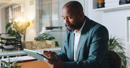 Black man, tablet and reading in office for business, research or scroll on news website....
