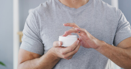 Man, hands or lotion with container for skincare, moisturizer or morning routine in home. Closeup,...