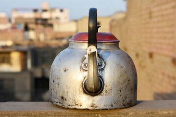 Old damaged metallic kettle.