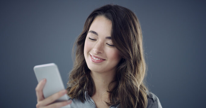 Message, phone and happy woman in studio for texting, social media blog and online post. Smile, technology or person with mobile for subscription, space and dating app notification on dark background