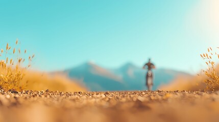 Cyclist rides on a dusty mountain road under a clear blue sky
