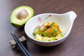 A photo of a bowl of edamame with chopsticks on the side.