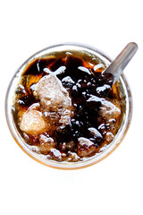 Grass jelly in a glass cup served with ice cubes is a classic Thai herbal dessert photographed from...