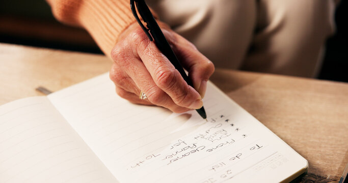 Senior, hands and notebook with writing in home for to do list, reminder or planner for alzheimers. Dementia, old person and diary for daily tasks, schedule and checklist to remember with memory loss - Powered by Adobe