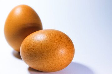 A fresh egg placed on a clean white surface, symbolizing simplicity, nutrition, and natural food. Ideal for themes related to cooking, health, or minimalism.