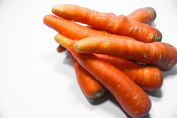Fresh organic carrots stacked on a clean white background. A healthy root vegetable rich in vitamin A, perfect for cooking, juicing, or raw consumption.