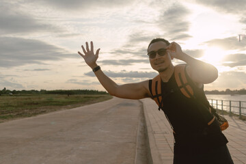 Man tourist backpacker hitchhike for pickup on the local country road.