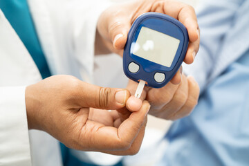 Doctor check diabetes from finger blood sugar level with finger lancet.