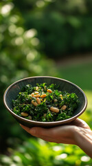 Person holding kale and white bean salad outdoors