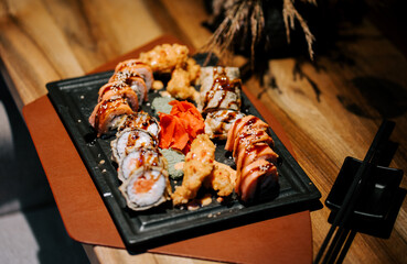 Sushi platter displayed elegantly on wooden table with vibrant colors in a cozy restaurant setting