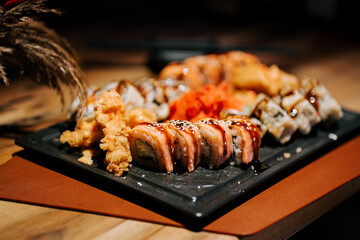 Sushi platter featuring various rolls and garnishes served on a rustic wooden table
