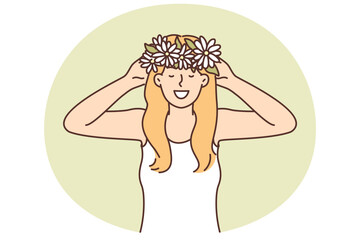 Woman puts on head wreath of spring flowers collected in meadow and rejoices at onset warm weather
