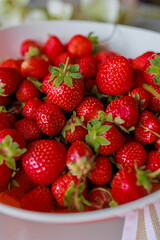 Fresh sweet strawberries in a white bowl on a white background. Seasonal berries.