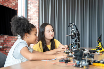 Young Girl and Friend Engaged in Robotics and STEM Learning, Diverse Kids Building a Robot Arm in a Science Workshop, Two Girls Exploring Technology and Innovation