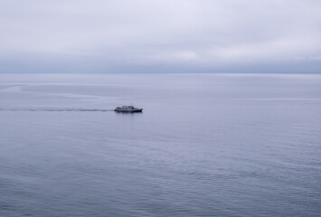 A lonely little sea vessel in the sea on the horizon.