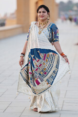 Elegant Indian Woman in White and Blue Saree with Traditional Palace Embroidery