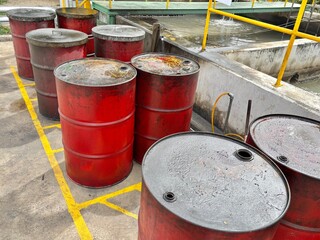 old oil barrel. Group of red oil barrels near wastewater treatment area, showing signs of corrosion...