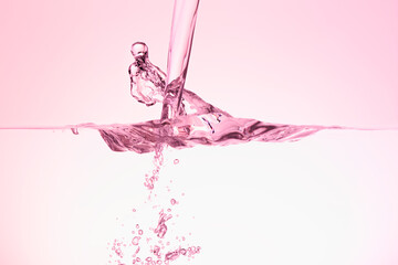 ピンクの背景に水槽に注ぐ水。