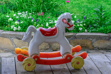 An empty children's swing on the veranda on a summer day