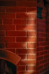 A fragment of a red brick wood-burning stove in close-up