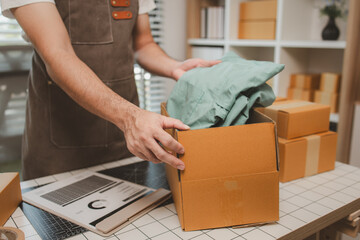 a small online business owner is checking boxes for accuracy before shipping to customers, parcel,...