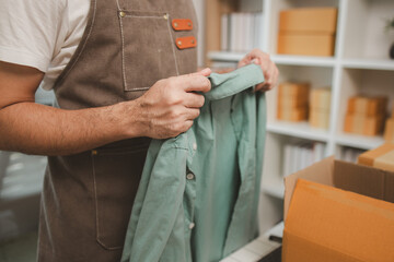 a small online business owner is checking boxes for accuracy before shipping to customers, parcel,...