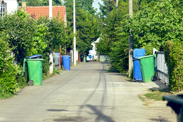 Concept of sustainable waste management: a view of a green suburban street, on both sides of which...