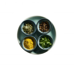 Four bowls containing various spices on a plate, showcasing vibrant colors and textures