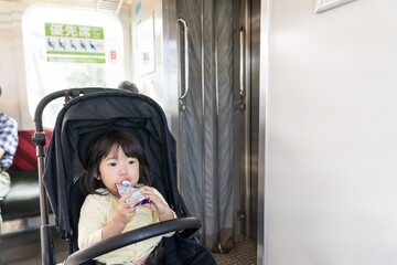 電車でおやつを食べる女の子