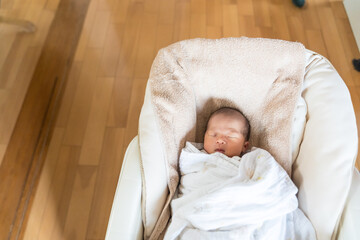 自宅のベビーチェアで寝る日本人の乳幼児