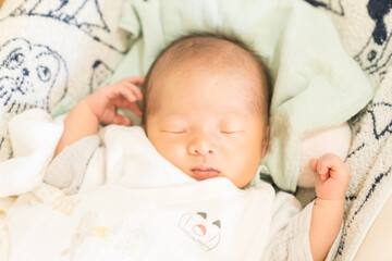 自宅のベビーチェアで寝る日本人の乳幼児