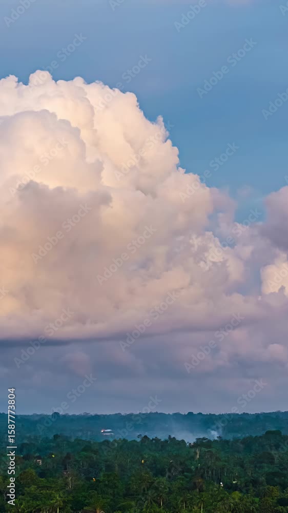 Aufkleber a mesmerizing vertical time-lapse of fluffy clouds changing shape and color above the dense balinese