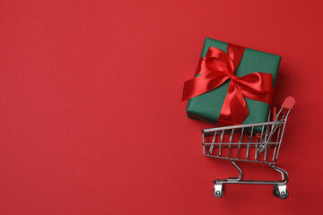 wheelbarrow with gift boxes on red background