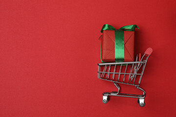 wheelbarrow with gift boxes on red background