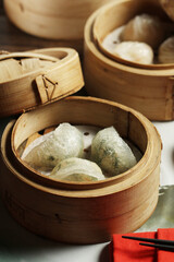 A delicious assortment of freshly steamed dim sum, including translucent crystal dumplings and other varieties, is presented in traditional bamboo steamers