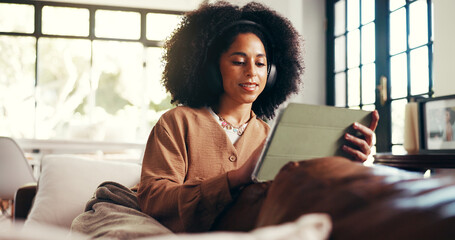 Headphones, woman or scroll with tablet on sofa for music search, streaming podcast or online show. Cozy, african person or relax with digital app in home with sound playlist, movie and weekend break