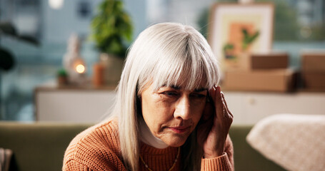 Mature woman, headache and home with stress on sofa for fatigue, strain or overthinking. Female...