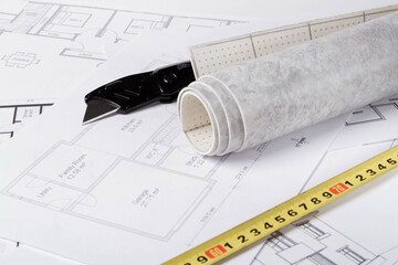 Laying flooring. Linoleum, a knife and a house plan on the builder's table. Taking measurements for laying the floor..