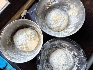 Evocative close-up image of a homemade pizza dough made with flour, water, salt and yeast
