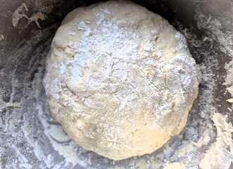 Evocative close-up image of a homemade pizza dough made with flour, water, salt and yeast
