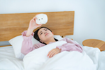 目覚まし時計を見る女性