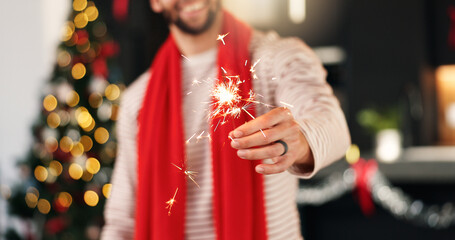 Hand, man and sparkler for Christmas celebration, festive holiday and home with bokeh. Xmas,...