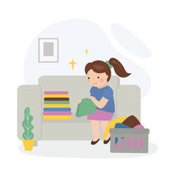 Little girl sitting on sofa and folding clothes. Kids doing housework chores at home concept. House work, Happy child helper.