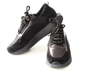 Black women's leather sneakers with laces. No logo. Fashionable Shoes on a white background. Close-up of a single black sneaker or sport shoe isolated on a white . Elegant and trendy mens footwear