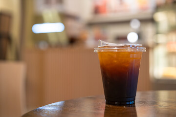 Close-up of Americano ice coffee or black coffee in cup mug on  wood desk office desk in coffee shop at the cafe in garden,during business work concept