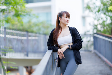 Portrait of beautiful asian Young woman in Black robe sportswear working out outside. training on...
