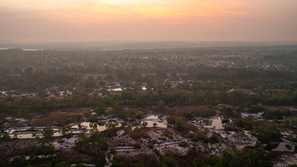Fototapeta premium A breathtaking view of a savanna landscape at sunrise, with warm hues of orange and pink illuminating the sky. A solitary tree stands prominently amidst the wilderness at Koh Phra Thong, Phang Nga.