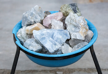 A blue bowl filled with various colored rocks